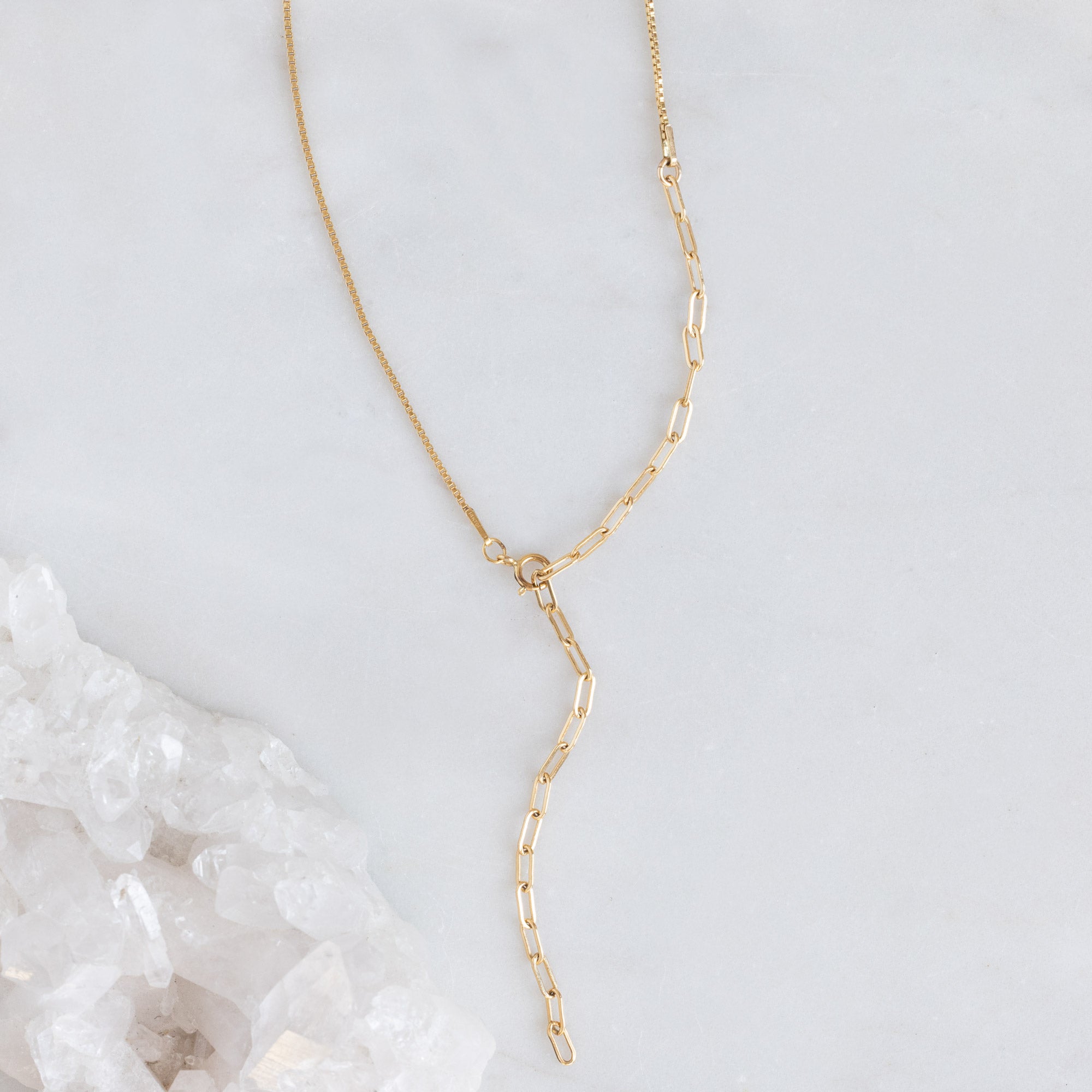 The 4-in-1 Cable Chain Necklace in 14K Yellow Gold on White Marble Surface