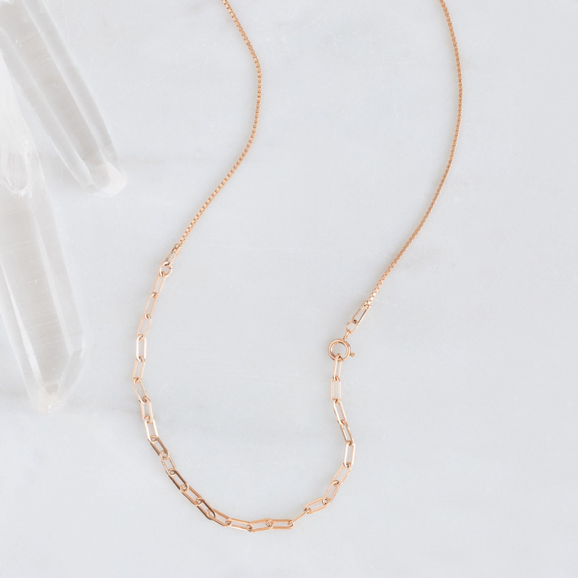 The 4-in-1 Cable Chain Necklace in 14K Rose Gold on White Marble Surface
