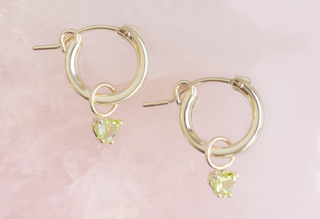 SIde View of Yellow Gold Peridot Heart Hoops on Pink Crystal