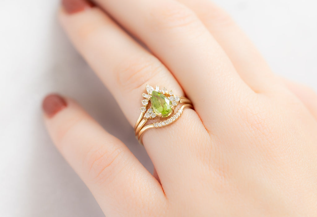 The Ivy Ring with a Pear-Cut Peridot with White Diamond Stacking Bands on Model