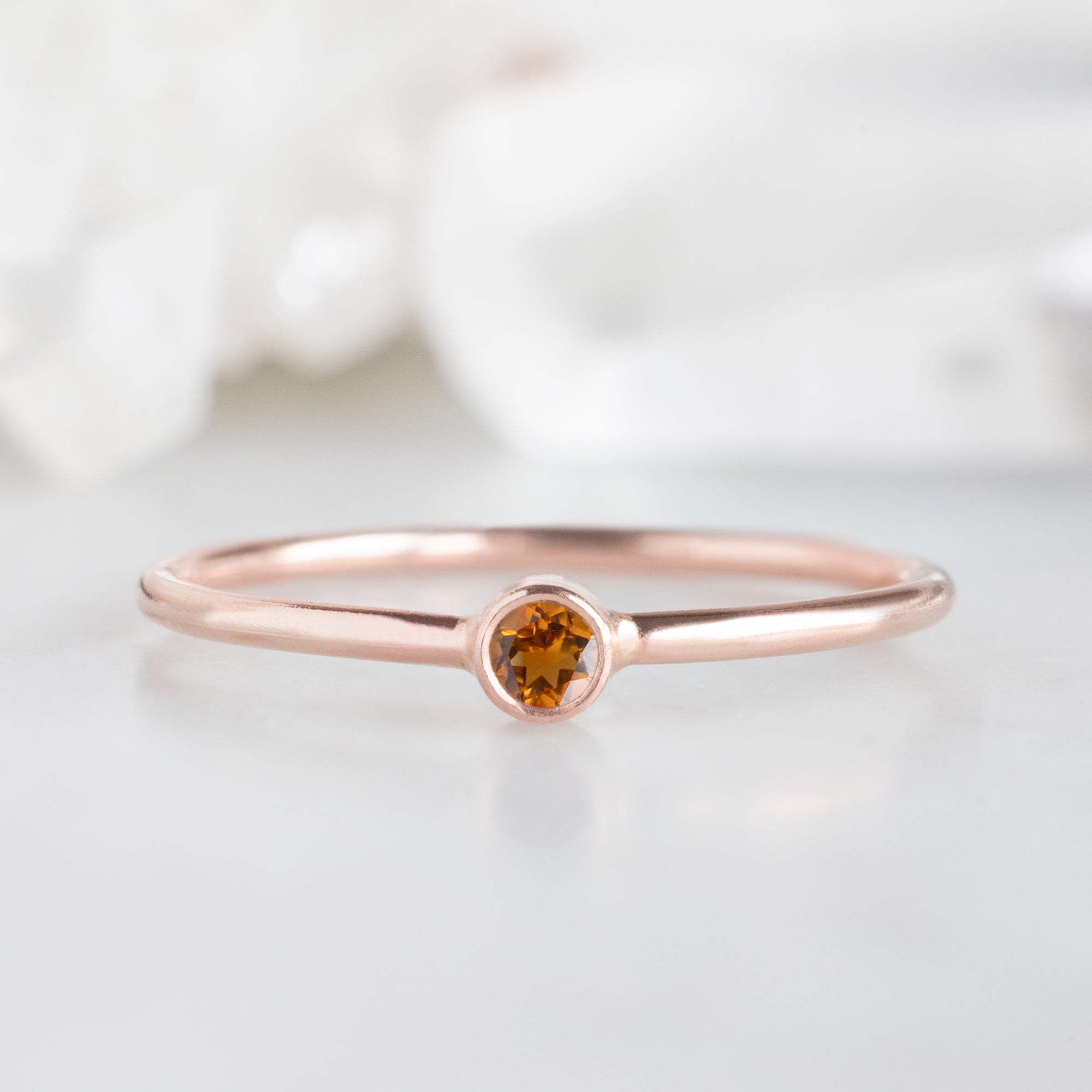 Custom Citrine Birthstone Stacking Ring | 10K Rose Gold displayed on marble surface.
