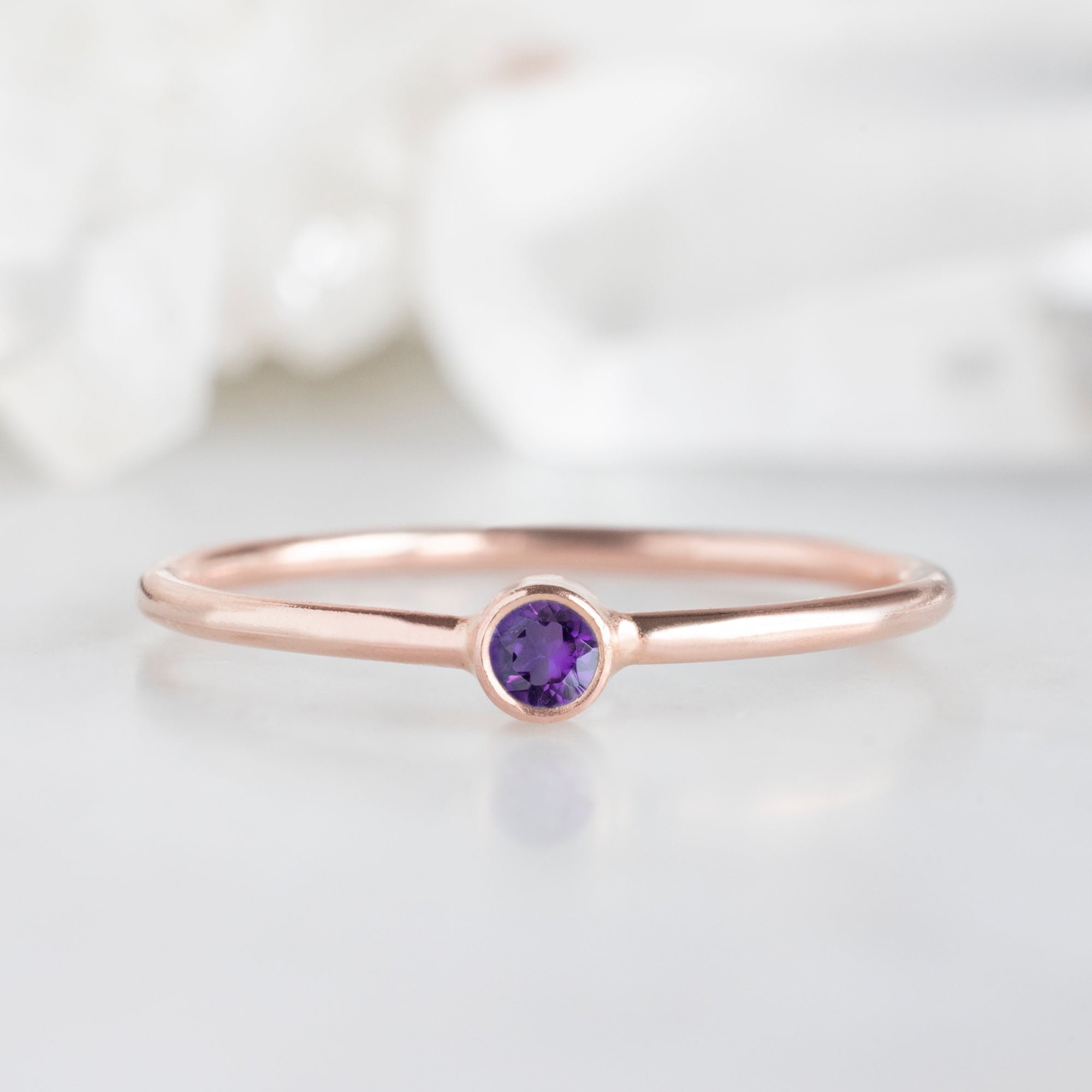 Custom Amethyst Birthstone Stacking Ring | 10K Rose Gold with white blurred background.