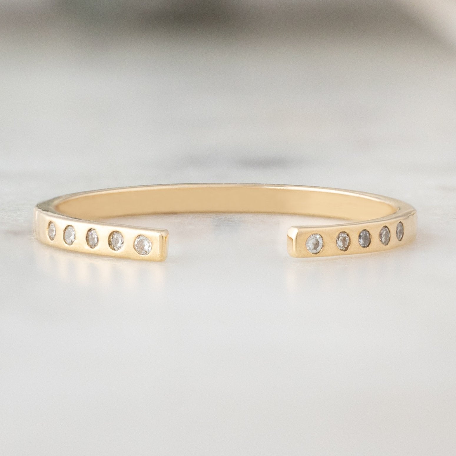 Open Cuff Flush Set Salt and Pepper Diamond Pavé Stacking Band in 14k Yellow Gold on White Marble