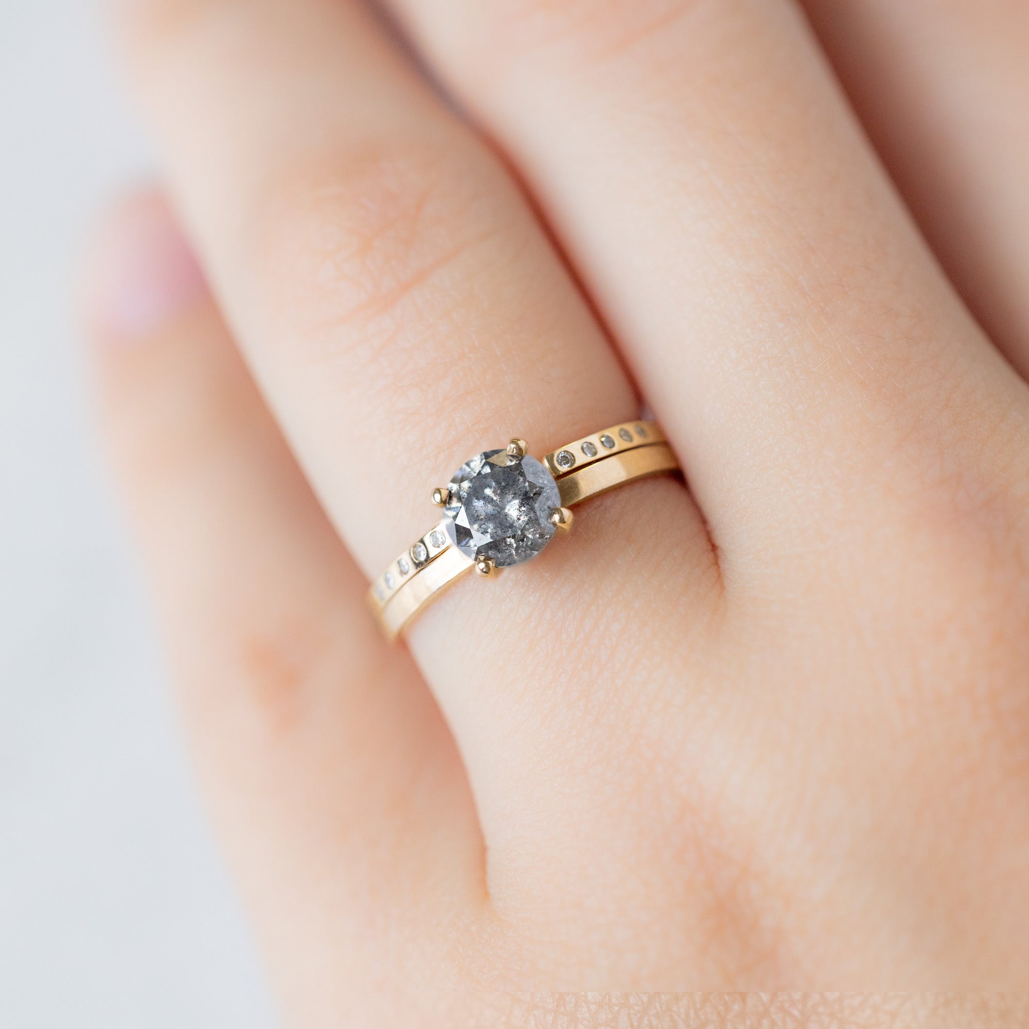 Open Cuff Flush Set Salt and Pepper Diamond Pavé Stacking Band in 14k Yellow Gold stacked with round diamond engagement ring on model