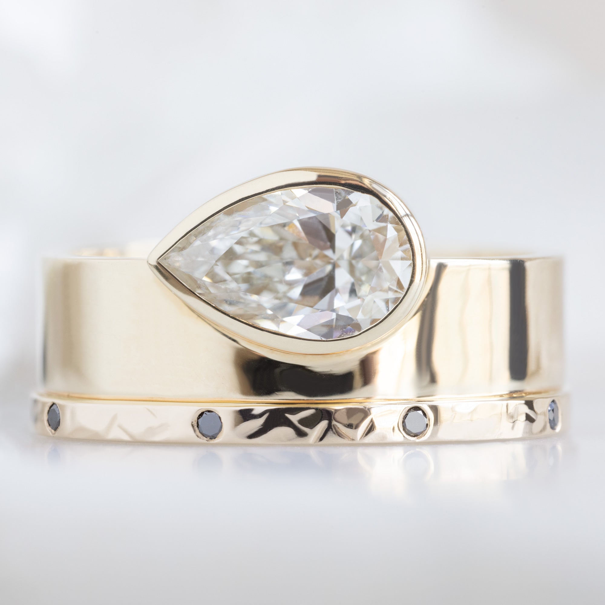 Black Diamond Eternity Band in 14K Yellow Gold Stacked with White Diamond Pear Cigar Band Engagement Ring