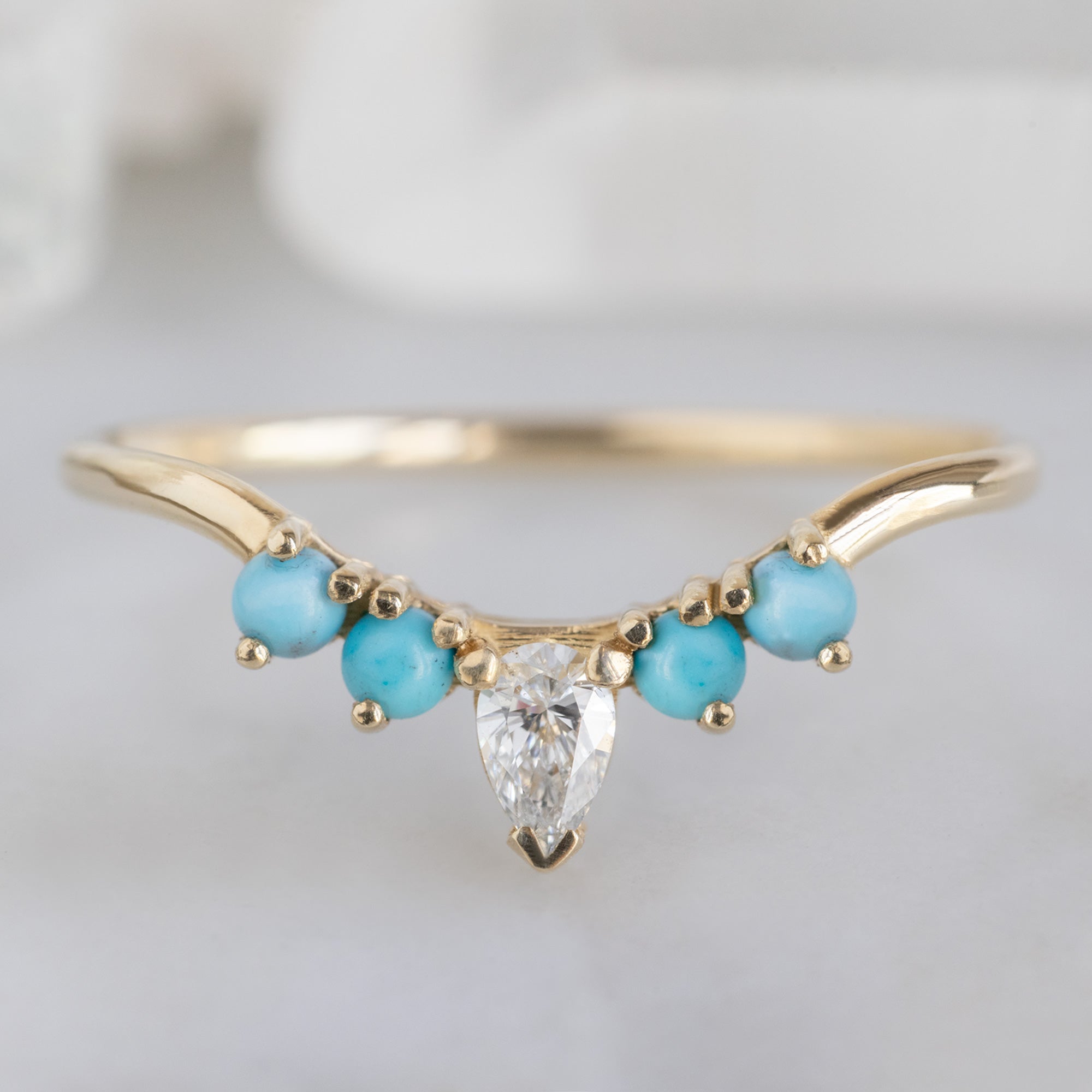 White Diamond and Turquoise 4-Stone Sunburst Stacking Band in 14K Yellow Gold on White Marble Tile