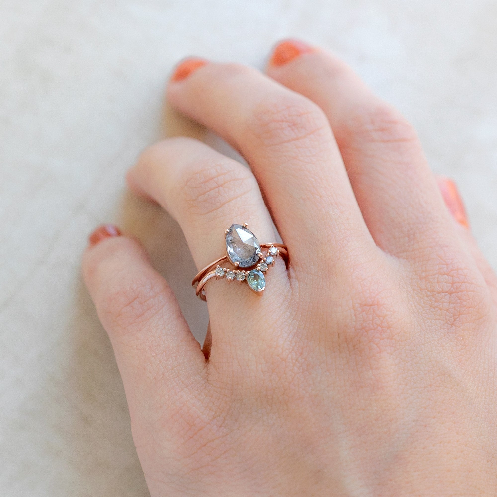One of a Kind Montana Sapphire and Salt and Pepper Diamond Sunburst Stacking Band in Rose Gold Stacked with Engagement Ring on Model