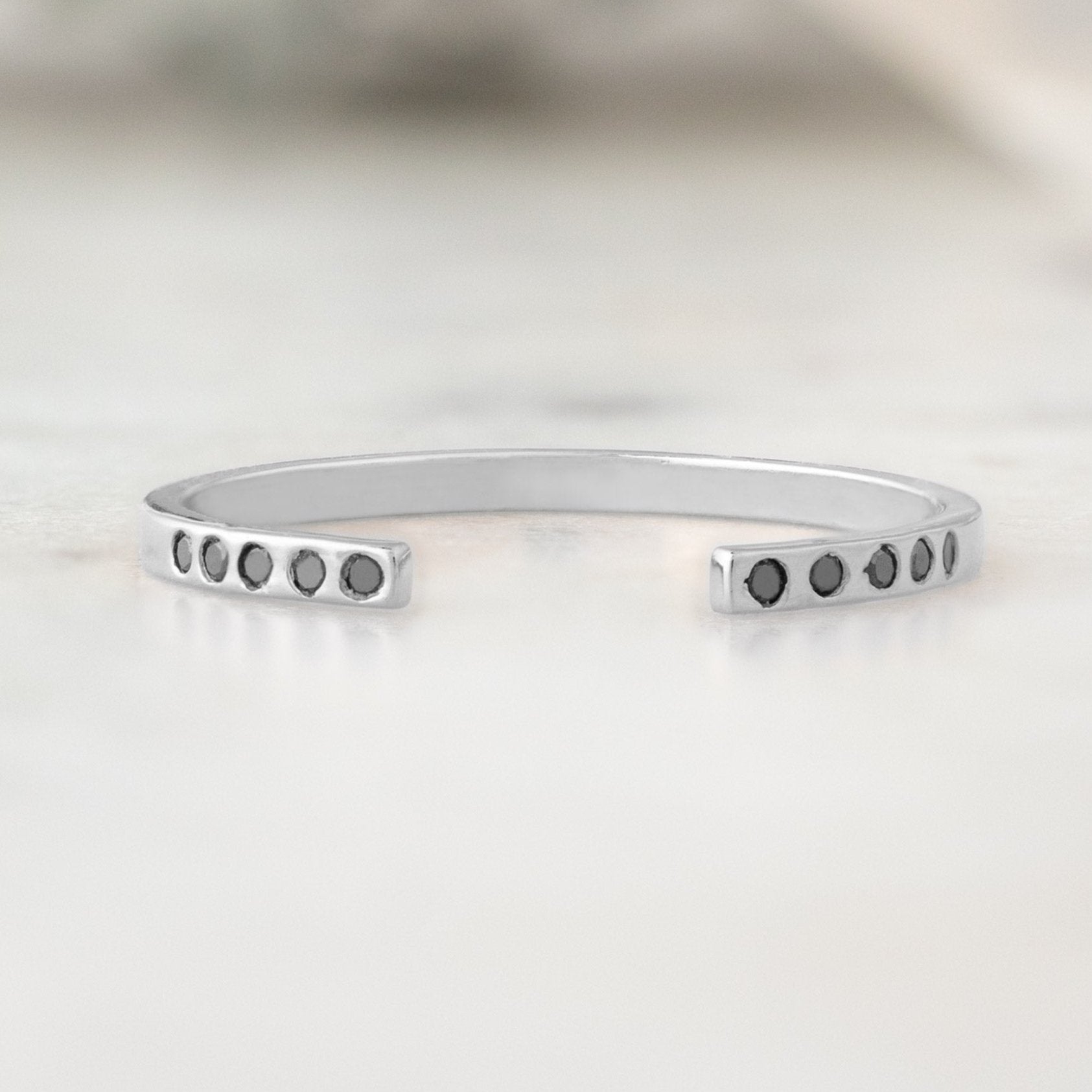 Open Cuff Flush Set Black Diamond Pavé Stacking Band in 14K White Gold on White Marble Surface