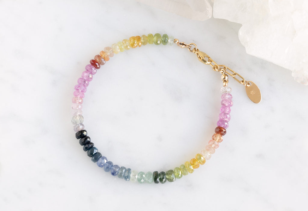 Rainbow Sapphire Beaded Bracelet Flat on Marble Tile