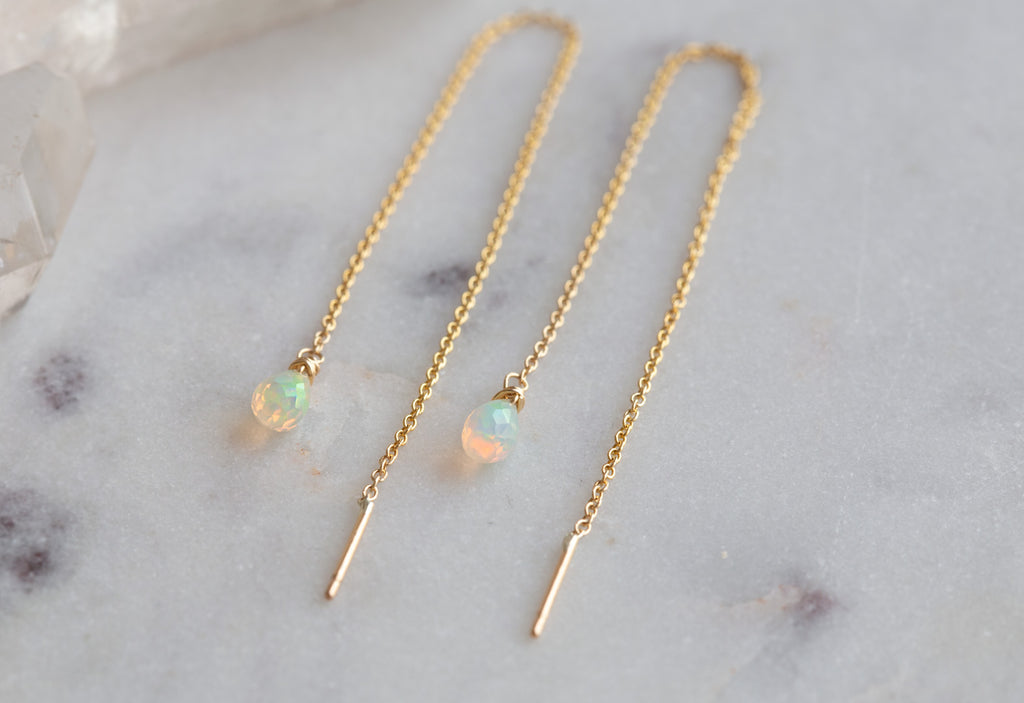 yellow gold Natural Opal Thread Earrings on white marble tile