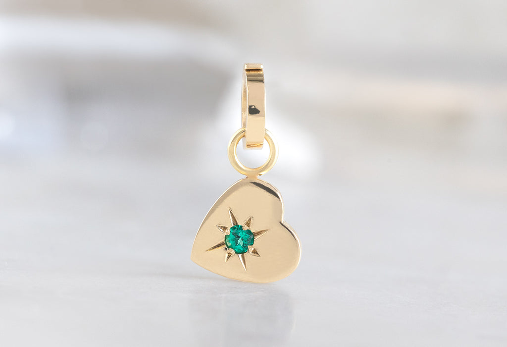 10k Yellow Gold Emerald Heart Charm on White Marble Tile