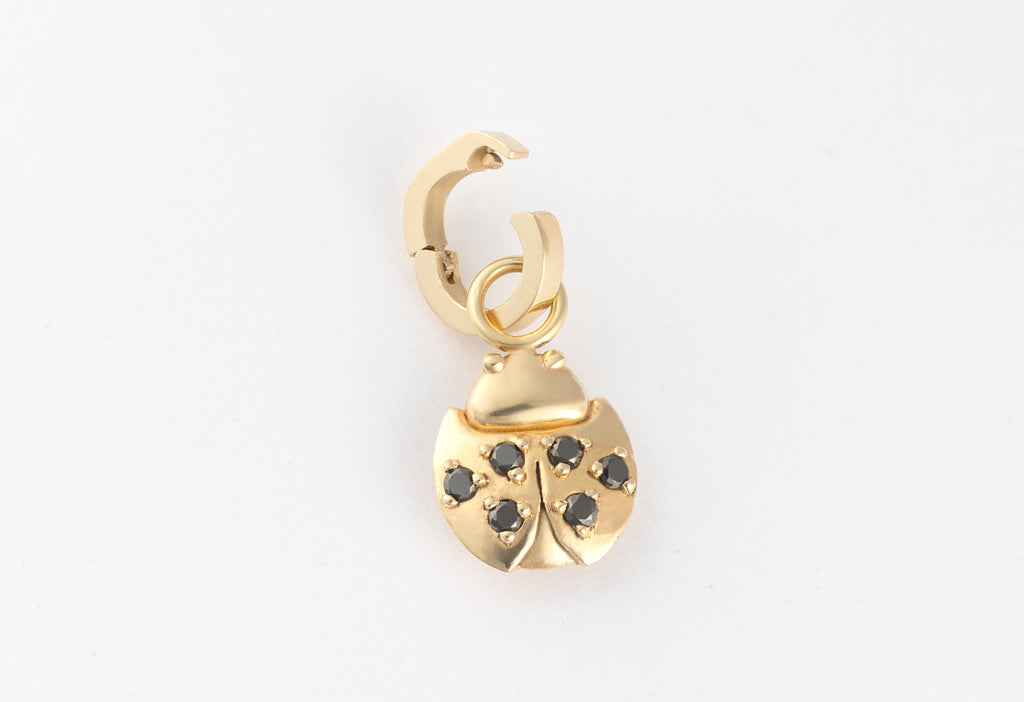 10k Yellow Gold Ladybug Charm with Open Interchangeable Charm Link on White Textured Paper