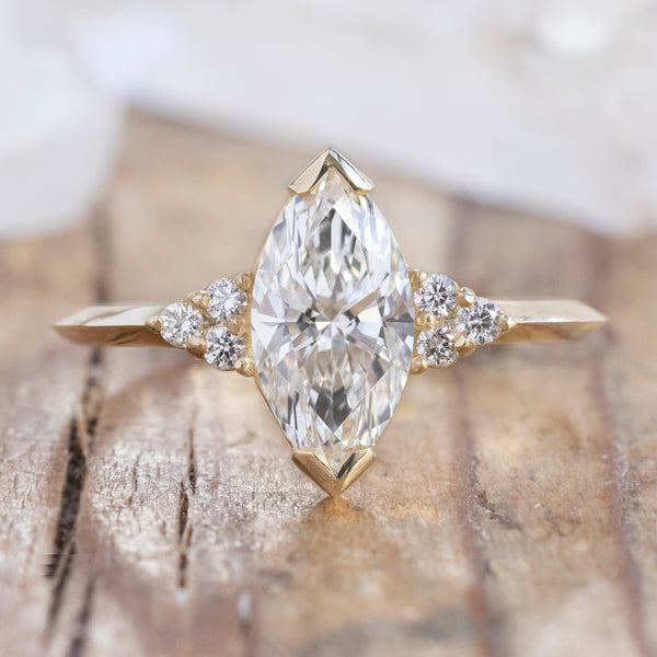 The Ivy Ring with a 1.17ct Marquise Lab Grown Diamond in 14K Yellow Gold on Wood Table