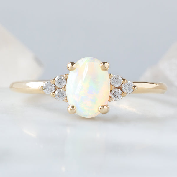 The Ivy Ring with a 0.96ct Oval Australian Opal in 14K Yellow Gold on White and Blue background