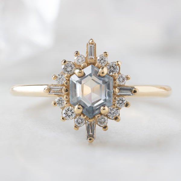 The Compass Ring with a 0.75ct Hexagon Grey Sapphire in 14K Yellow Gold on White Marble