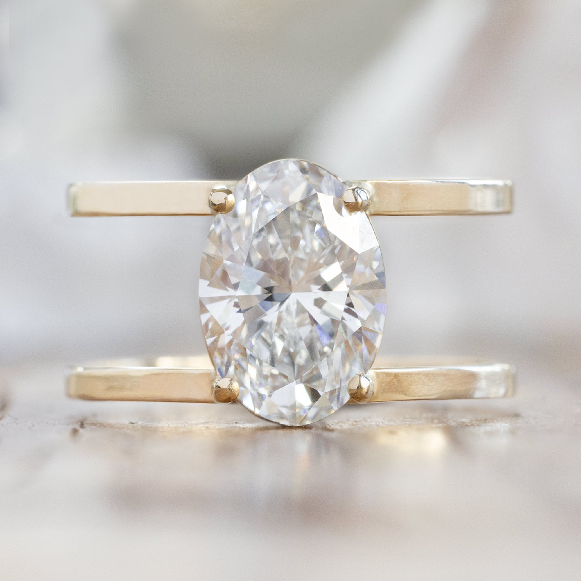 The Poppy Ring with a 3.06ct Oval Lab Grown White Diamond in 14K Yellow Gold on White Marble