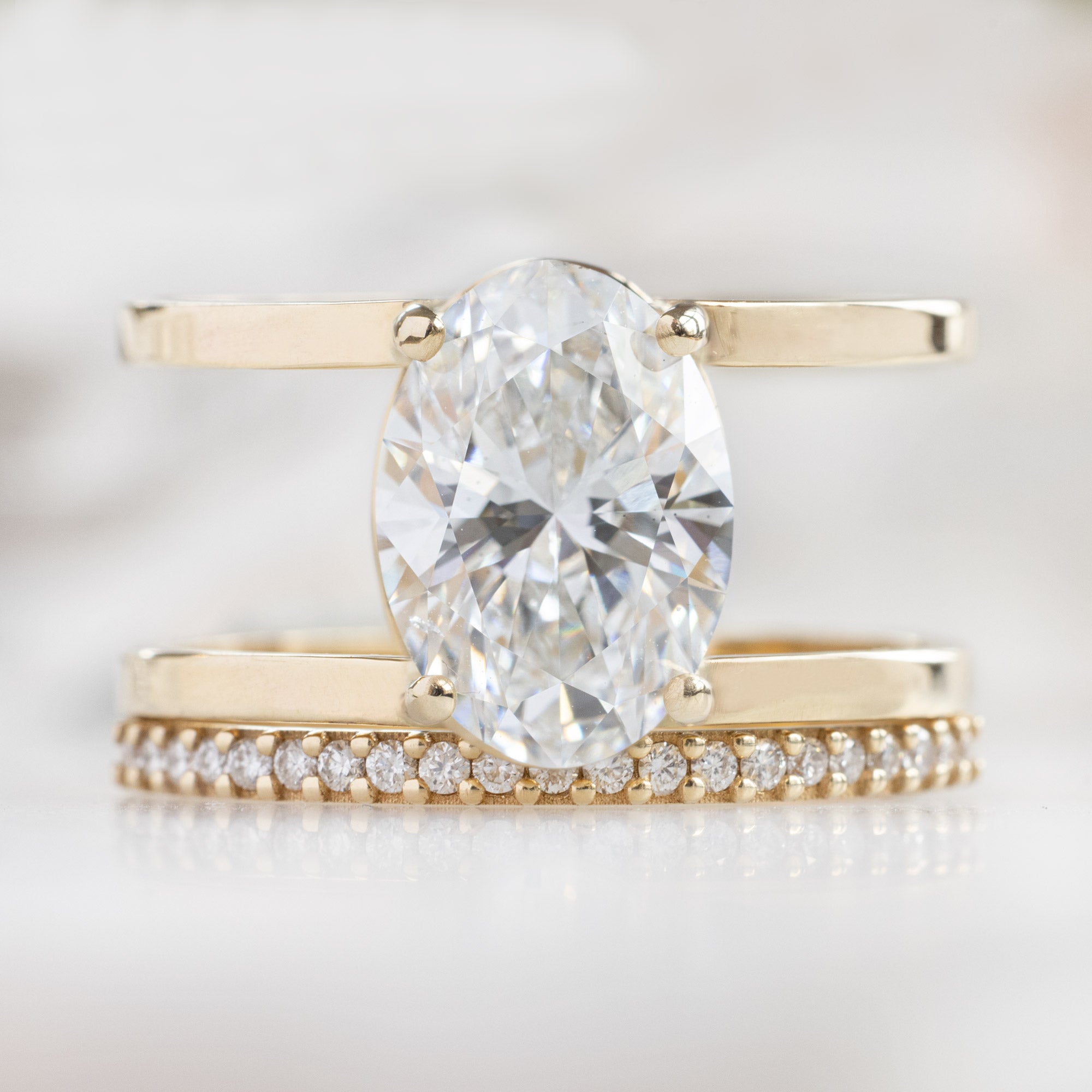 The Poppy Ring with a 3.06ct Oval Lab Grown White Diamond in 14K Yellow Gold Stacked with the White Diamond Pavé Stacking Band