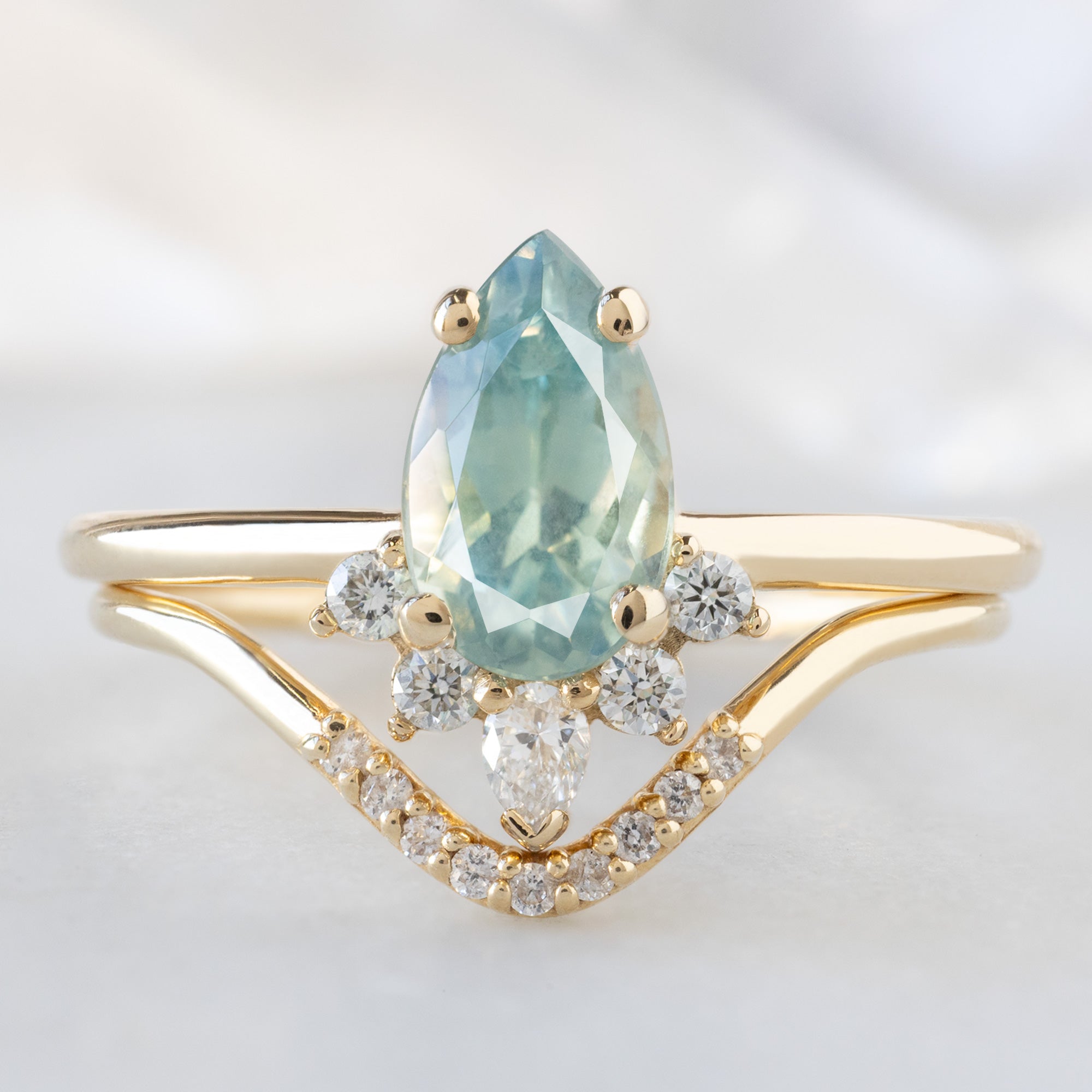 The Aster Ring with a 1.18ct Pear Blue Sapphire in 14K Yellow Gold Stacked with the White Diamond Pavé Peak Stacking Band