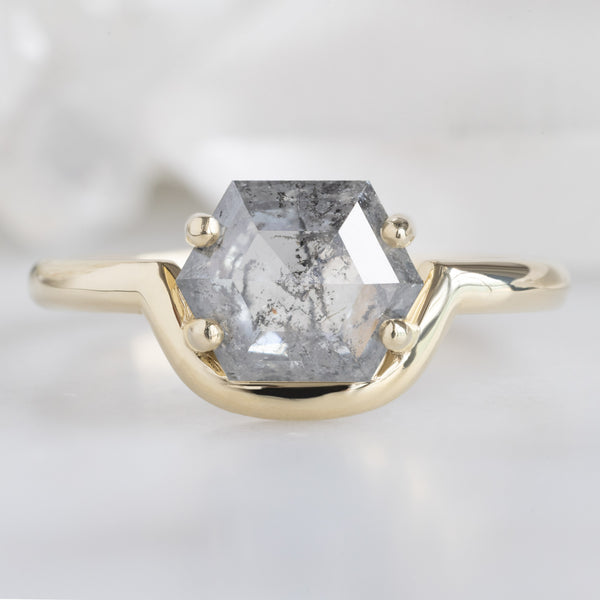 The Wave Ring with a 1.37ct Hexagon Salt and Pepper Diamond in 14K Yellow Gold on White Marble Surface