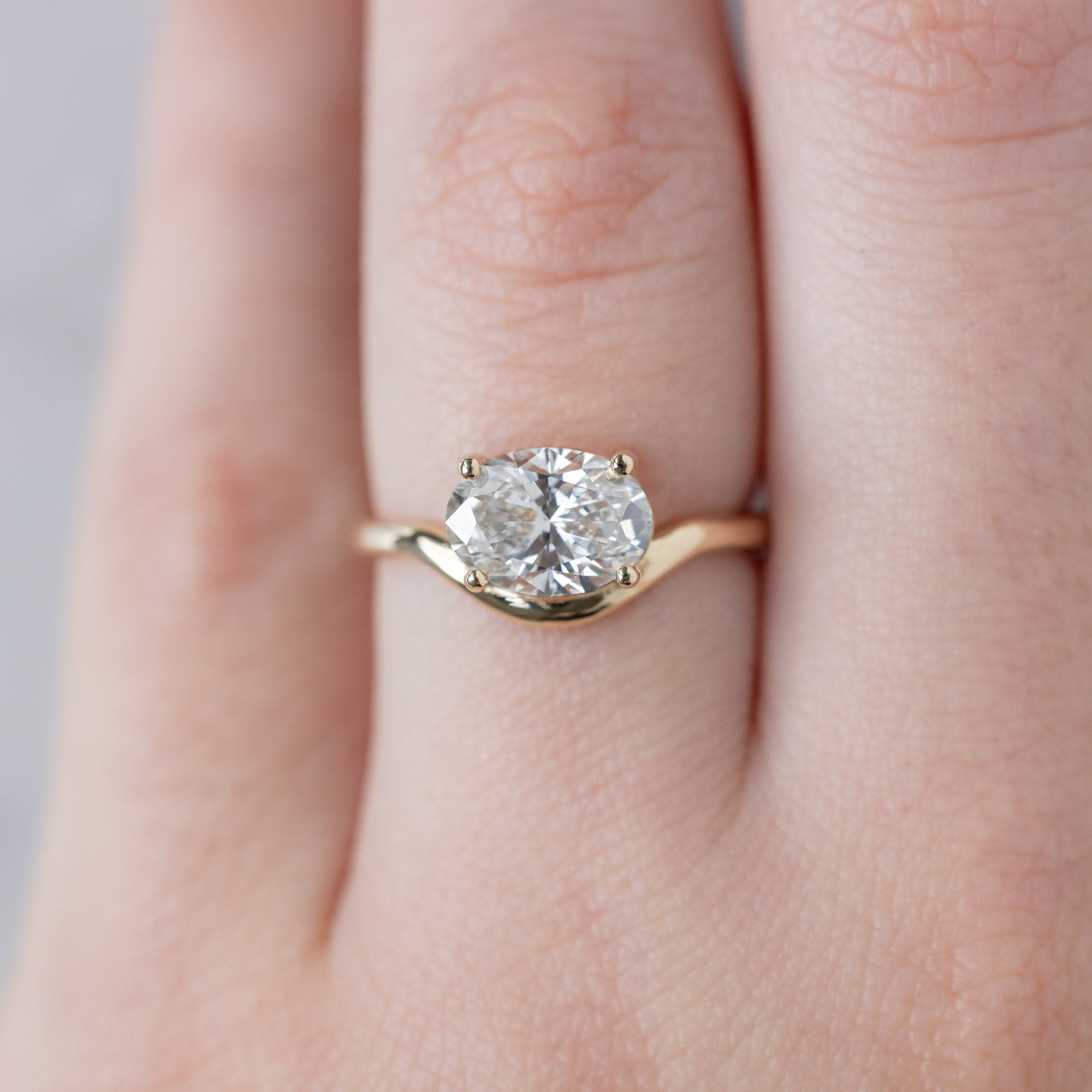 The Wave Ring with a 1.59ct Oval Lab Grown White Diamond in 14K Yellow Gold on Model