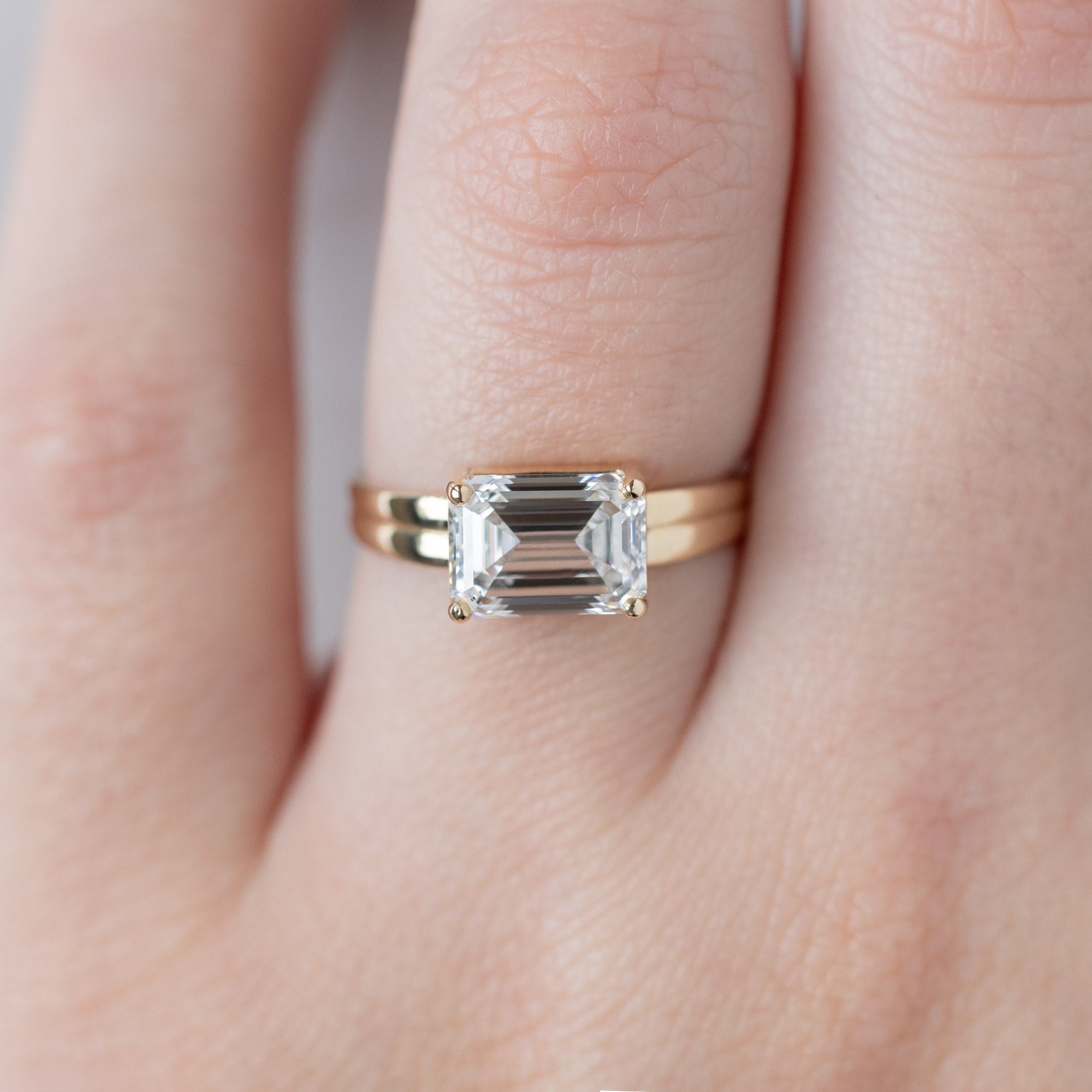 The Stratum Ring with a 1.96ct Emerald Cut Lab Grown White Diamond in 14K Yellow Gold on Model