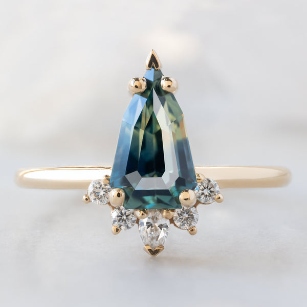 The Aster Ring with a 1.56ct Geometric Montana Parti Sapphire in 14K Yellow Gold on White Marble Surface