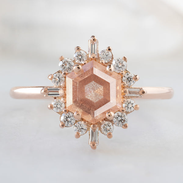 The Compass Ring with a 0.98ct Hexagon Sunstone in 14K Rose Gold on White Marble Surface