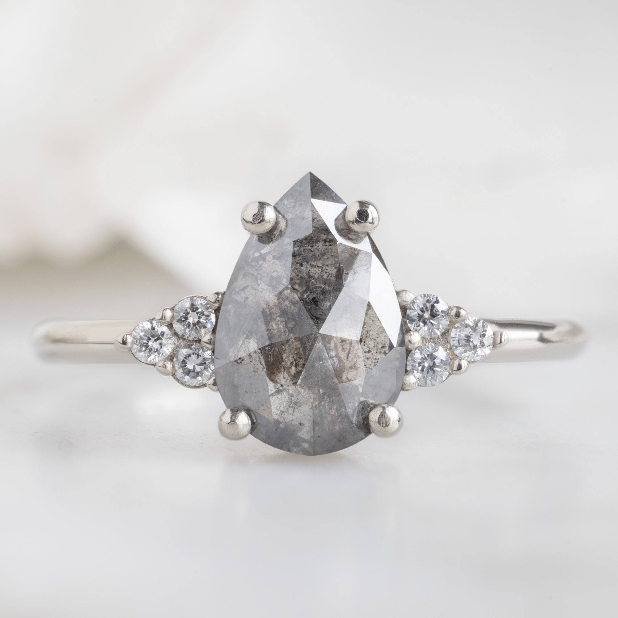 The Ivy Ring with a 1.46ct Pear Salt and Pepper Diamond in 14K White Gold on White Marble