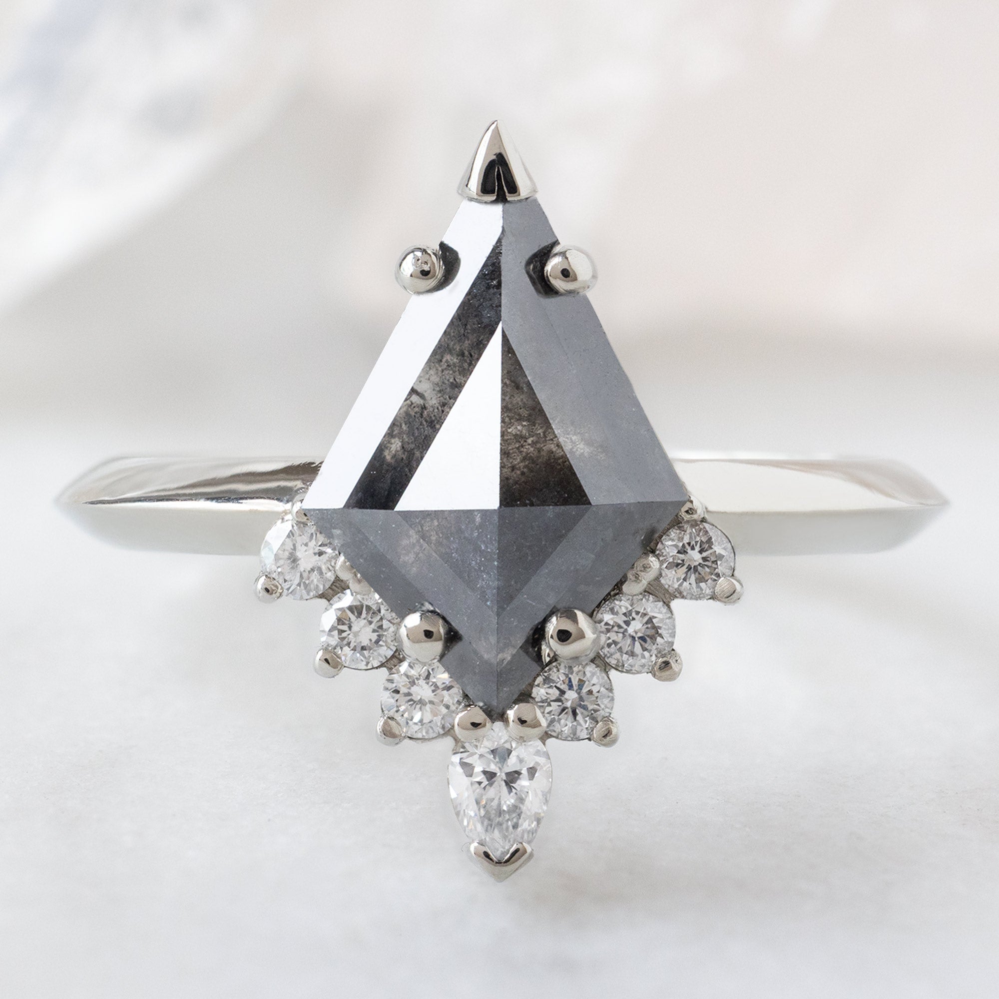 The Aster Ring with a 1.44ct Kite Black Diamond in 14K White Gold on White Marble Surface