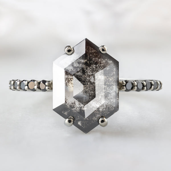 The Luxe Willow Ring with a 1.53ct Hexagon Lab Grown Salt and Pepper Diamond in 14K White Gold on White Marble Background