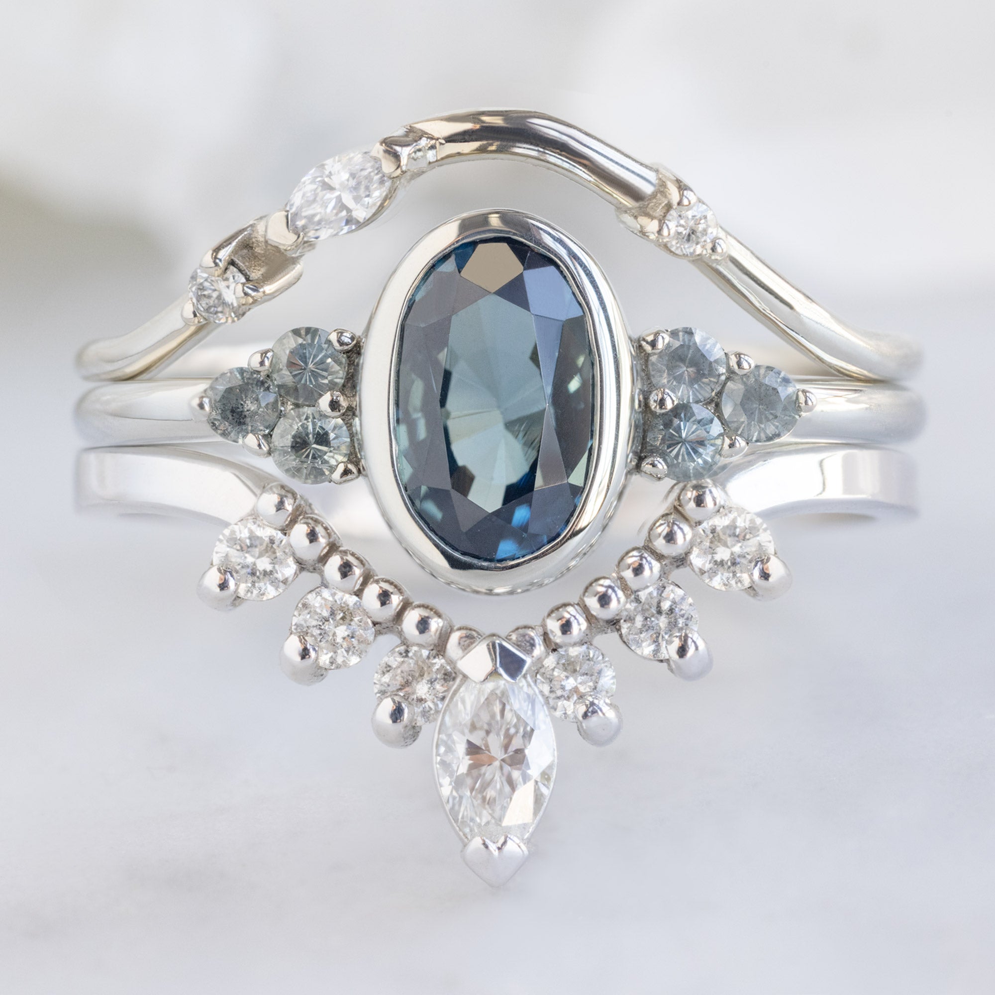 buy:asymmetrical-baguette-diamond-arc-stacking-band-in-14k-yellow-gold,the-ivy-ring-with-a-1-58ct-oval-blue-sapphire-in-14k-white-gold,marquise-white-diamond-sunburst-stacking-band-14k-gold