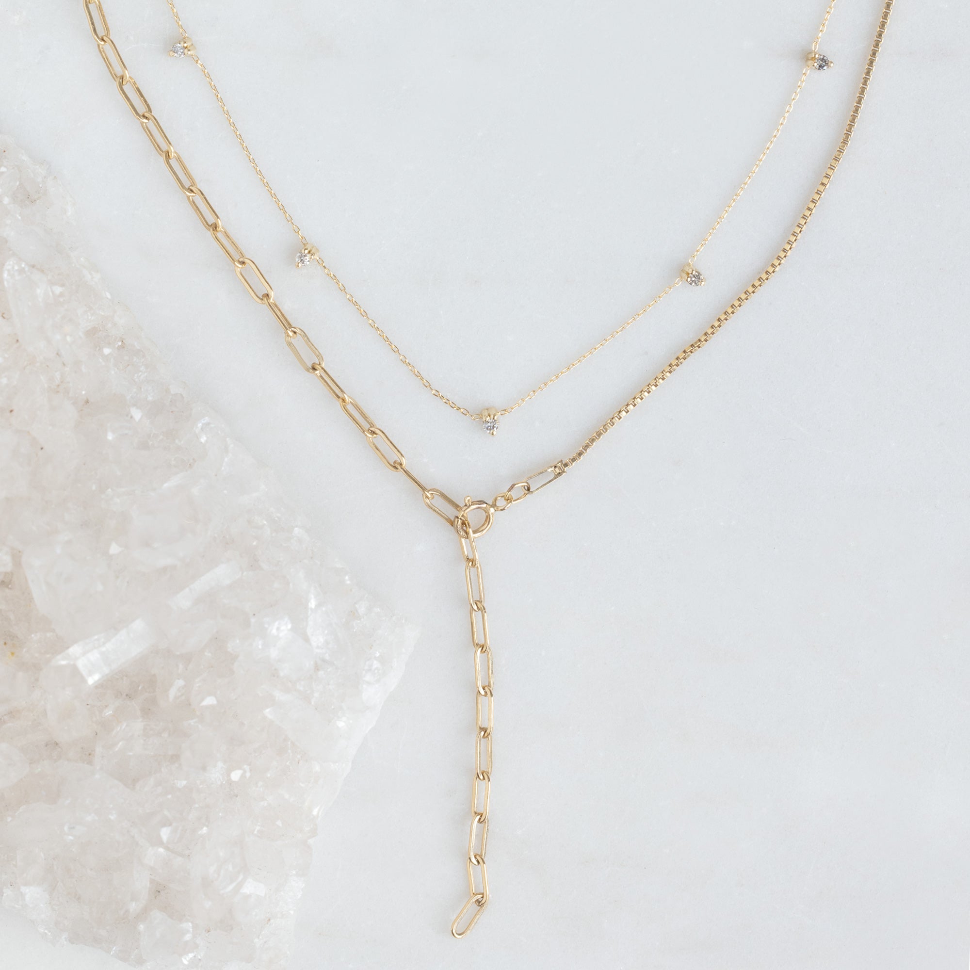 The Sunburst Chain Set in Yellow Gold on White Marble Surface