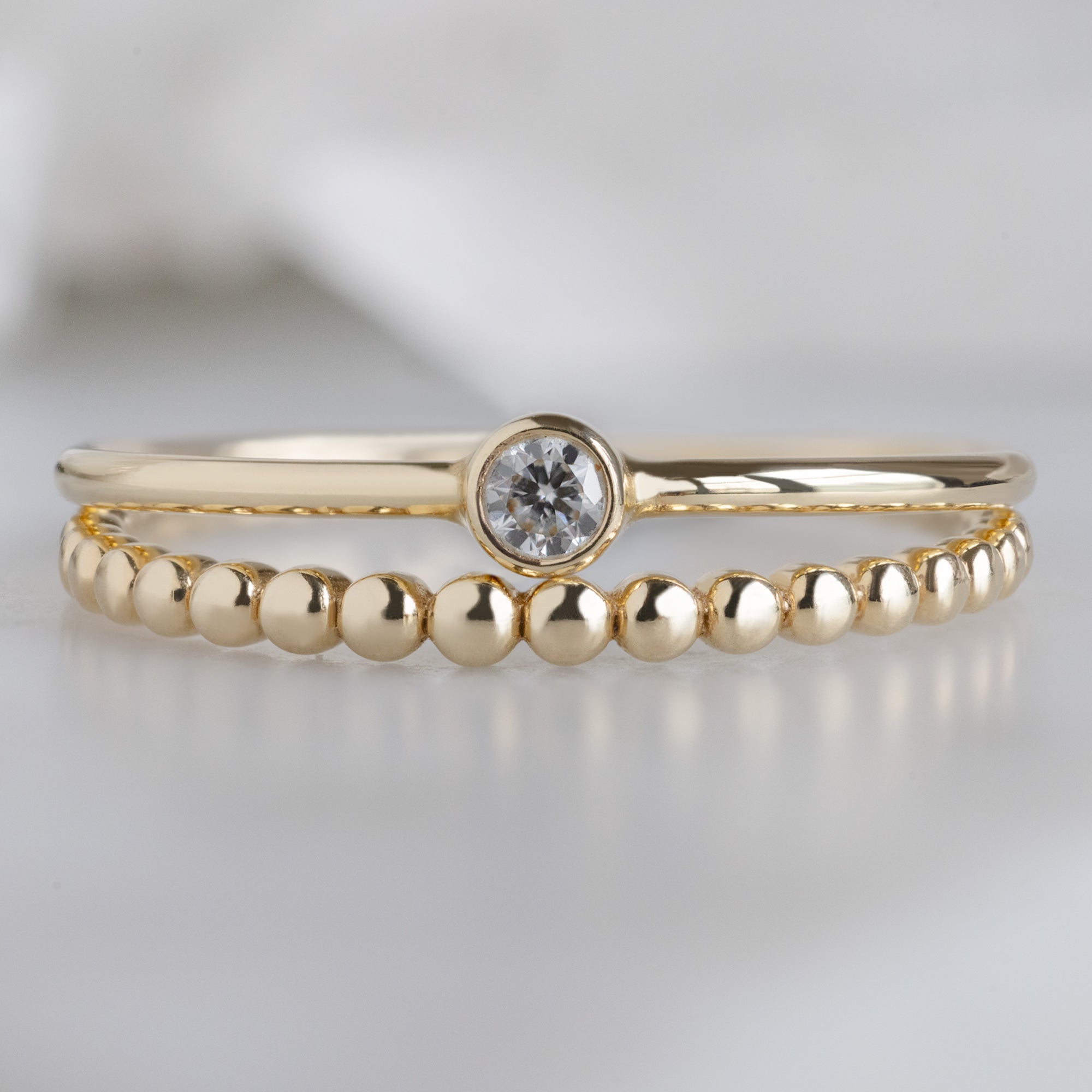 The Textured Ring Set in Yellow Gold on White Marble Surface