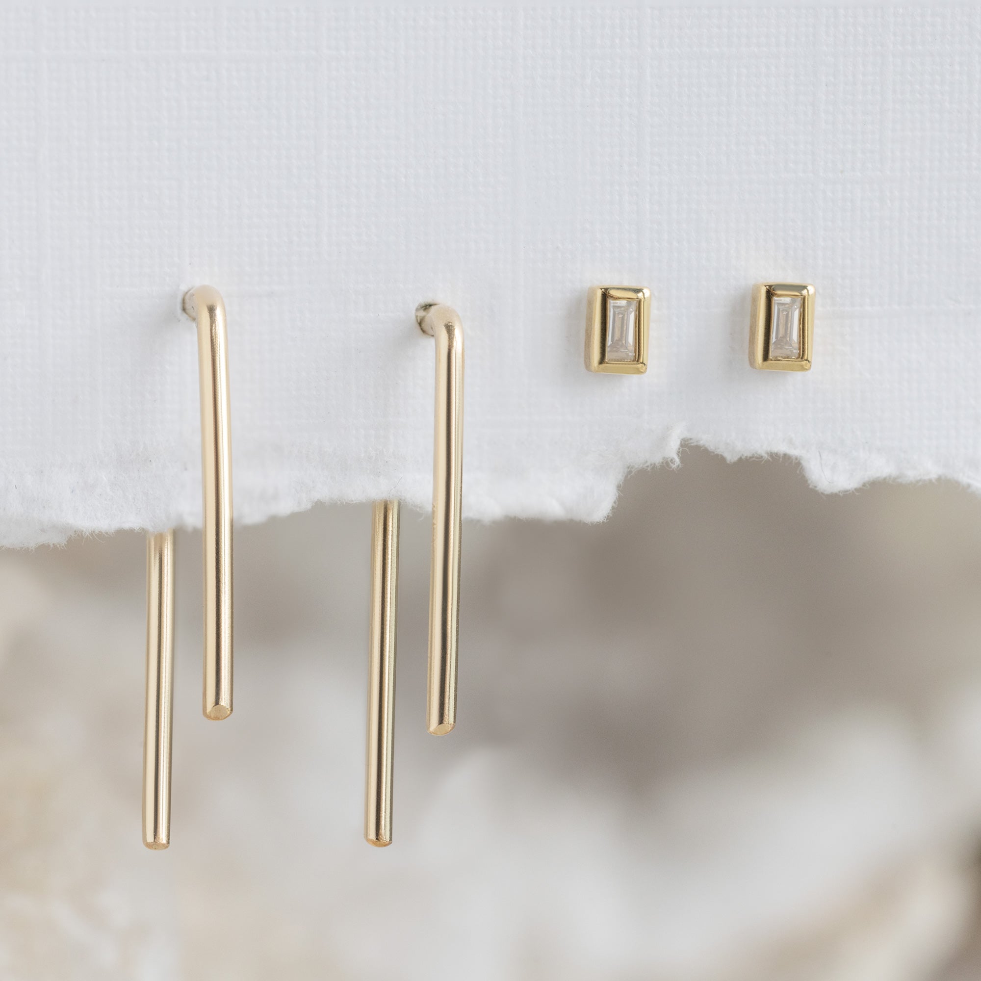 The AR Crew Fave Earring Set hanging on white textured paper