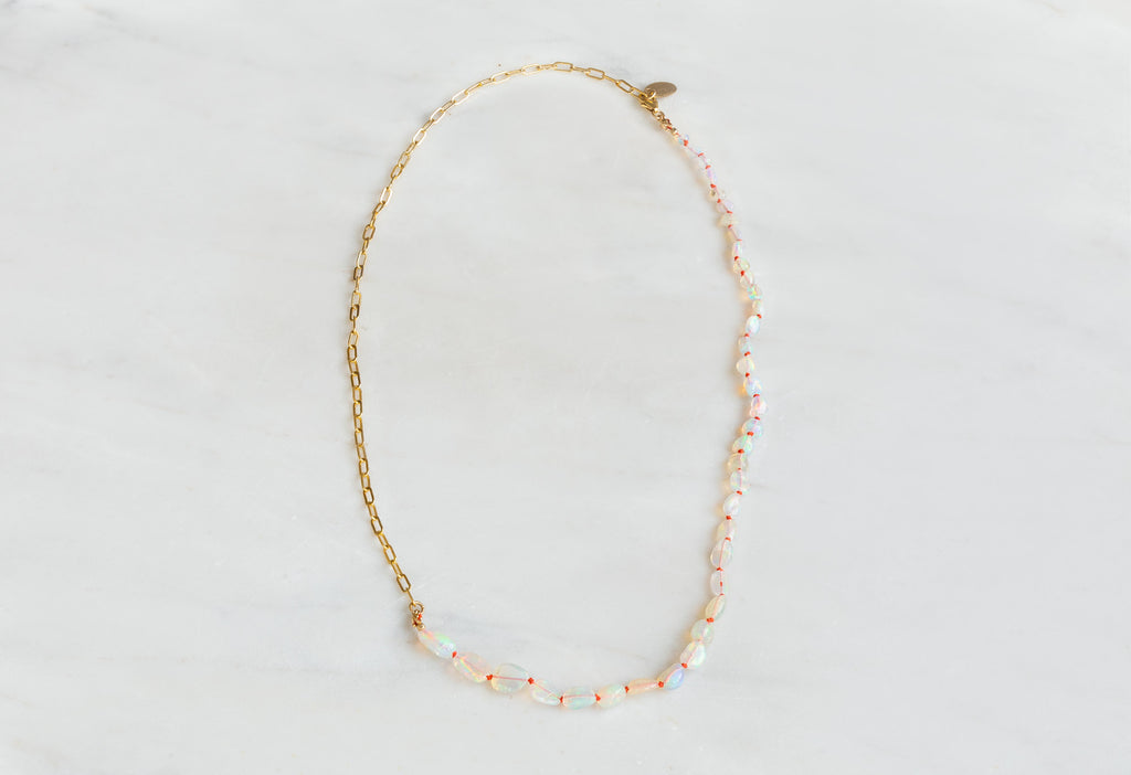 Knotted Opal Necklace on White Marble Tile