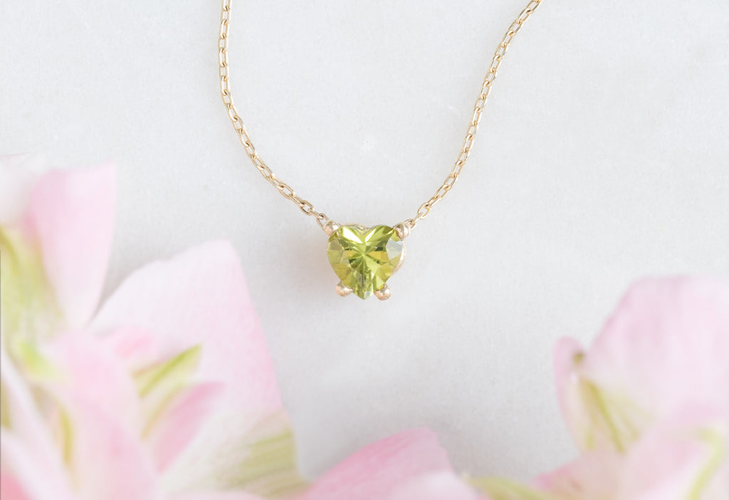 Sweetheart Peridot Necklace with Pink Flowers in the Background