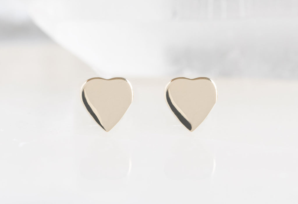 10k Yellow Gold Sweetheart Stud Earrings on White Marble Tile