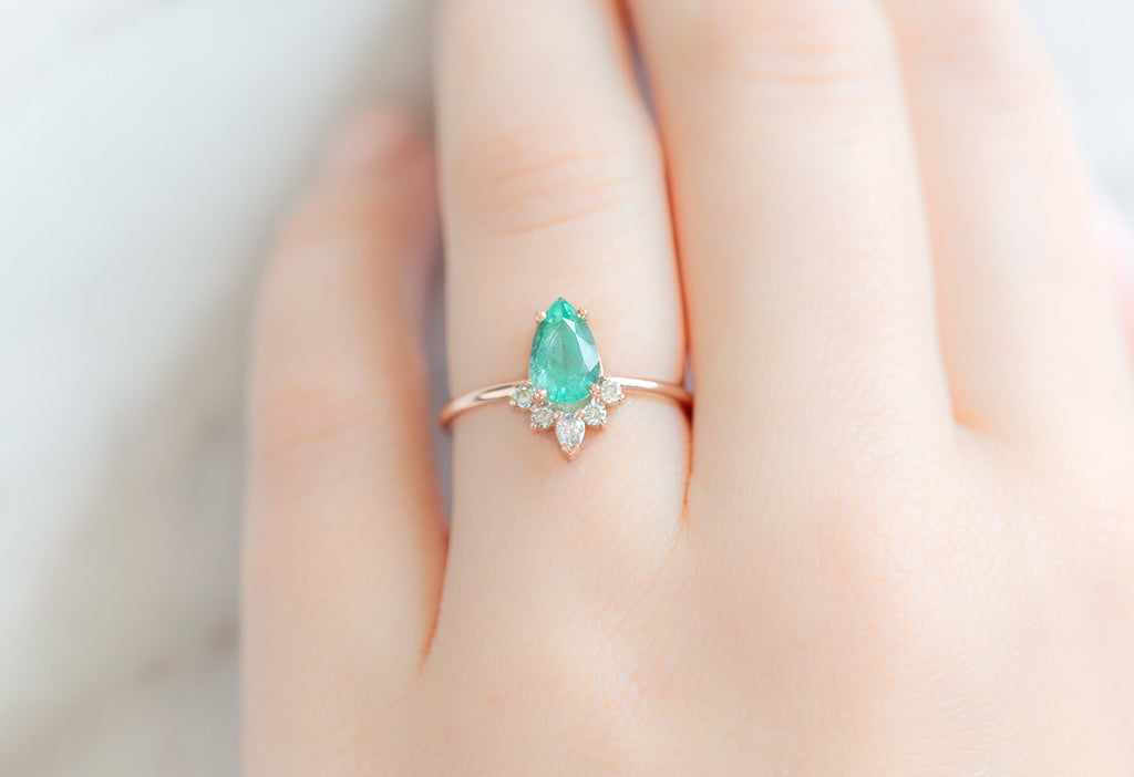 The Aster Ring with a Pear-Cut Emerald on Model