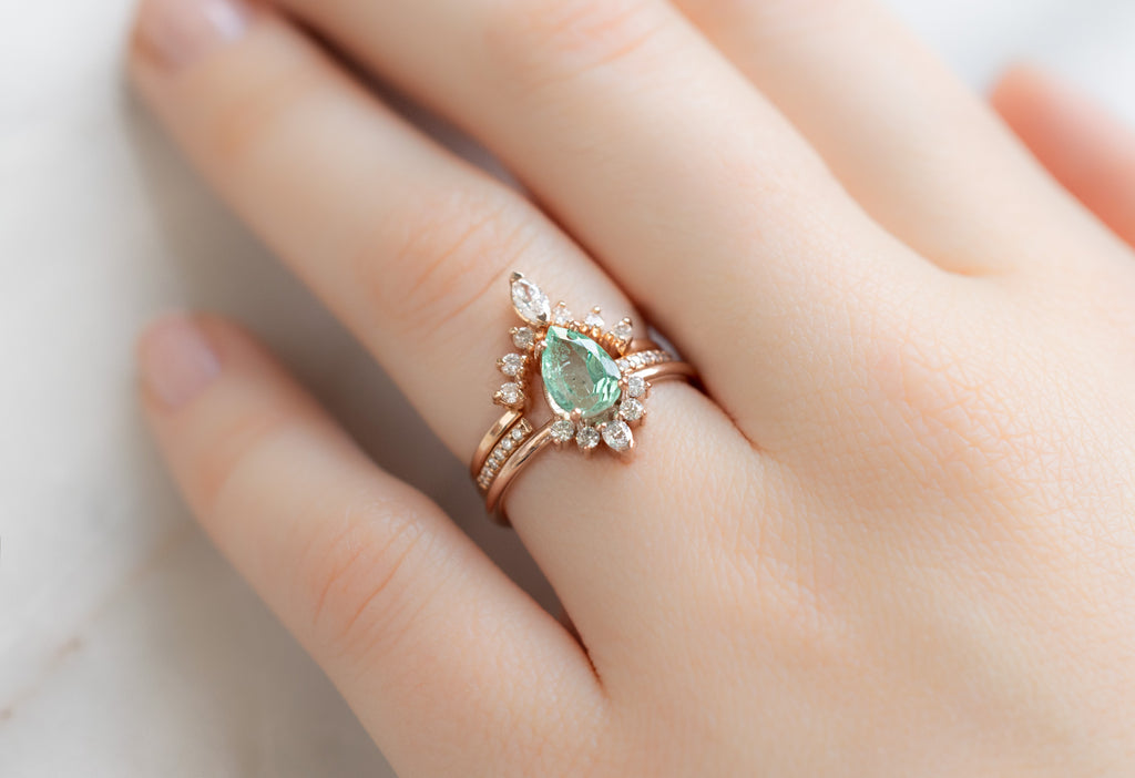 The Aster Ring with a Pear-Cut Emerald with White Diamond Stacking Bands on Model