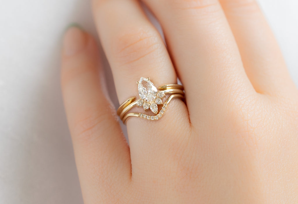 The Aster Ring with a Pear-Cut White Diamond with Stacking Bands on Model