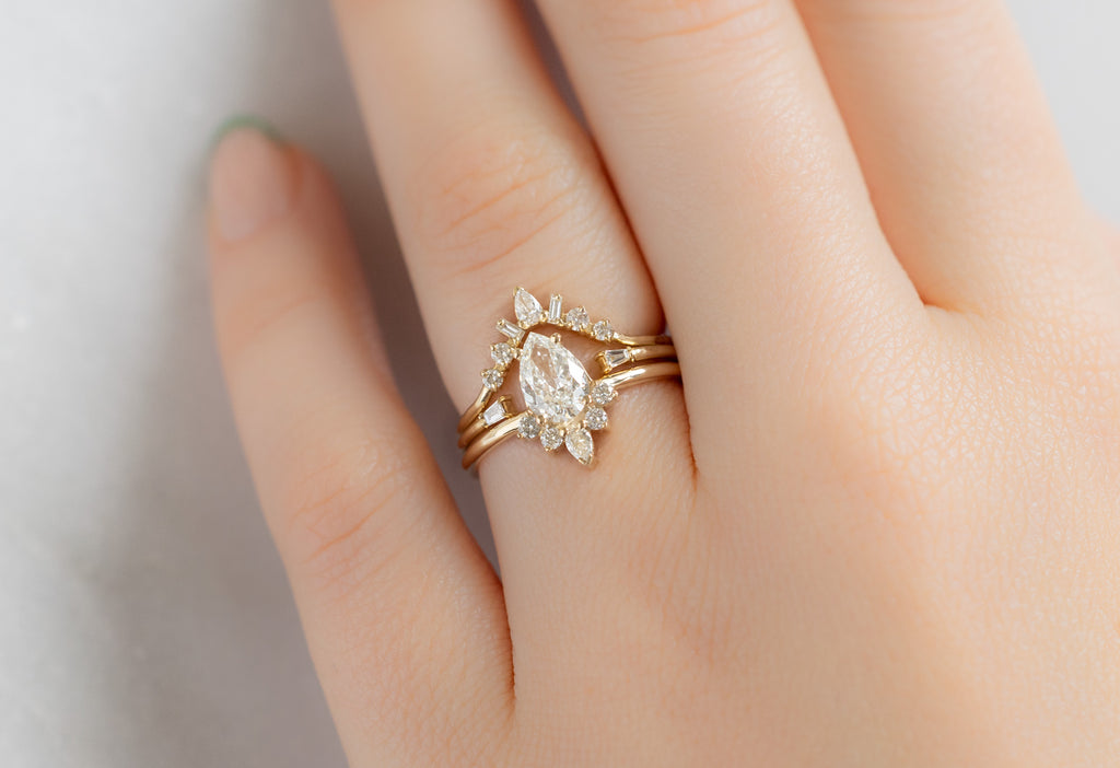 The Aster Ring with a Pear-Cut White Diamond with White diamond Stacking Bands on Model