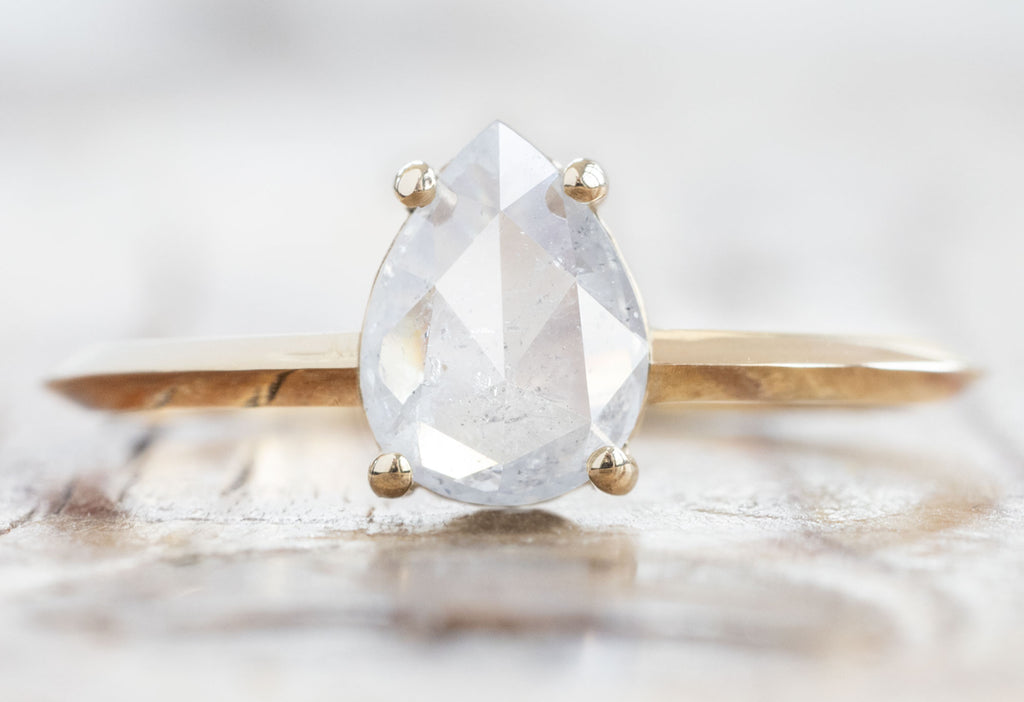 The Bryn Ring with a Rose-Cut Icy White Diamond on Wood Table