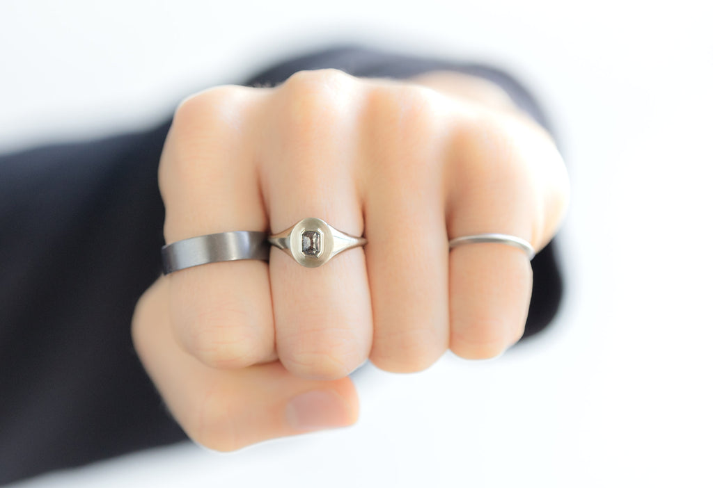 The Emerald-Cut Black Diamond Signet Ring Stacked on Model Making a Fist