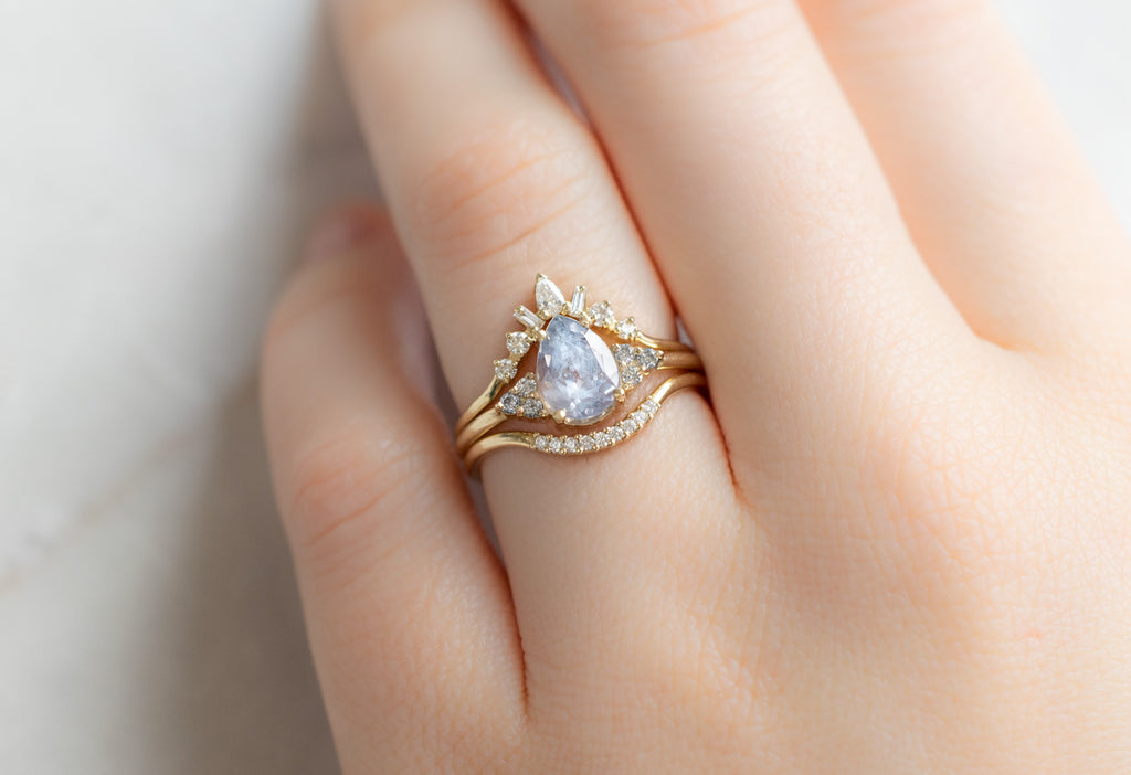 The Ivy Ring with a Pear-Cut Montana Sapphire with White Diamond Stacking Bands on Model