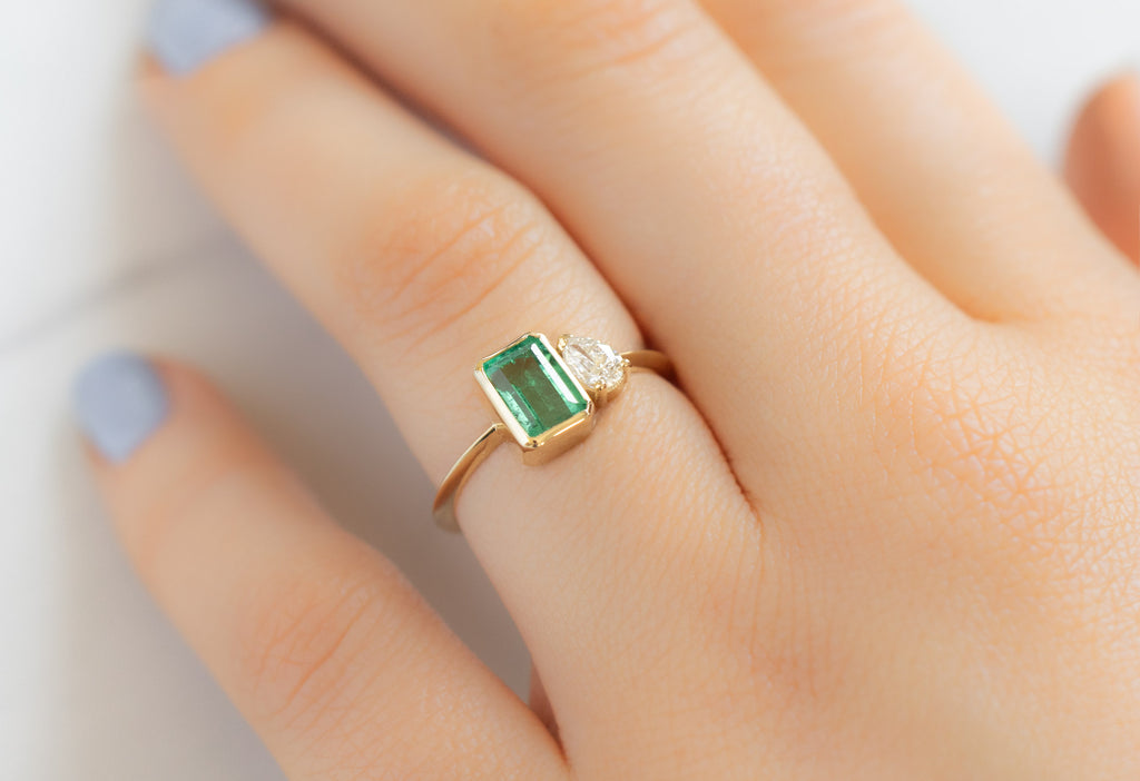 The You & Me Ring with an Emerald + White Diamond on Model