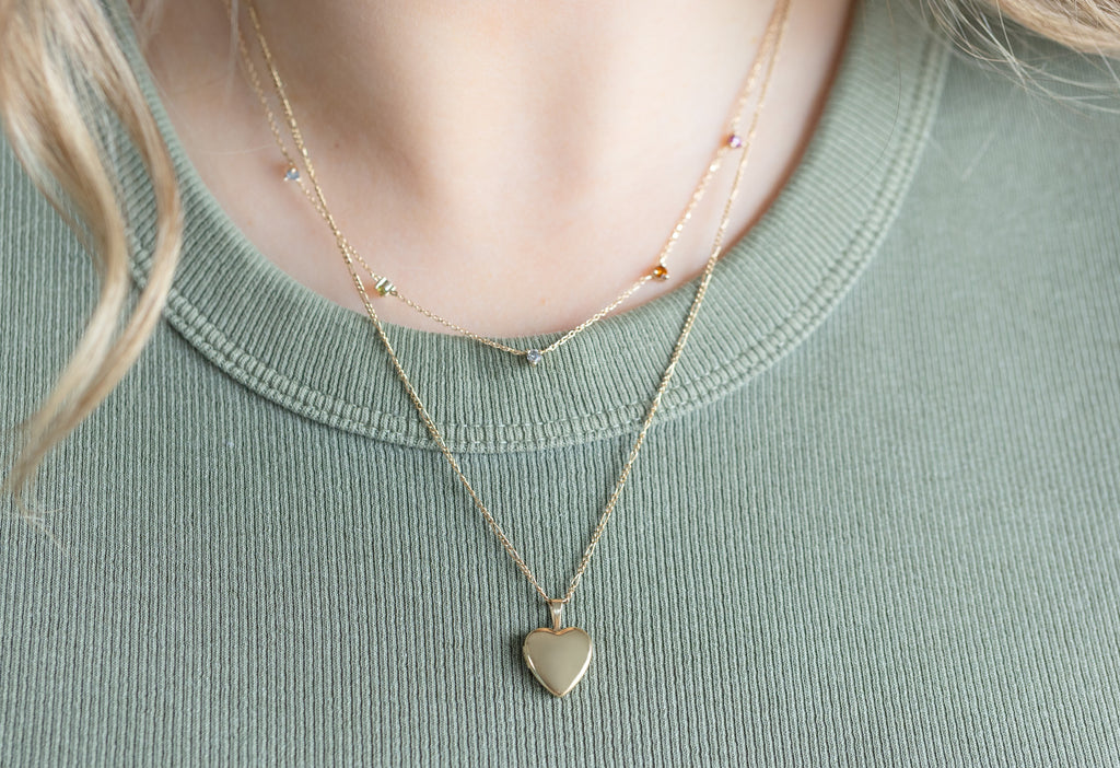 Yellow Gold Filled Mini Sweetheart Locket Necklace Layered on model wearing Green Ribbed Tank