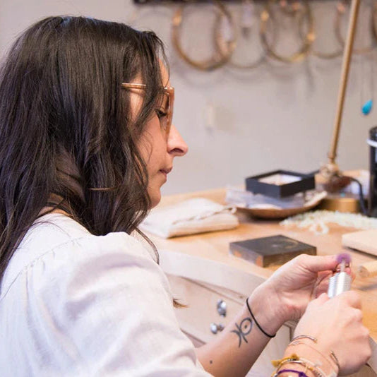 Alexis Russell crafting a fine jewelry ring at their jewelry bench