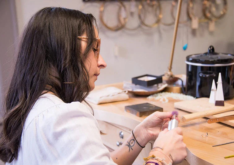 Alexis Russell crafting a fine jewelry ring at their jewelry bench