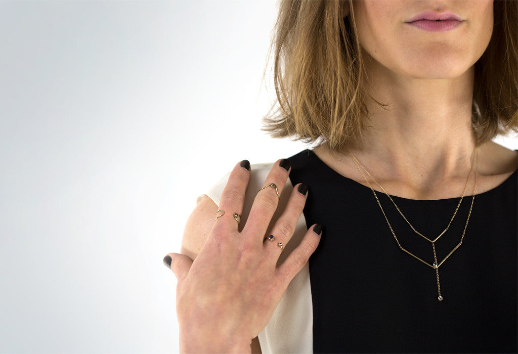 Model wearing a variety of Alexis Russell Jewelry Pieces in front of white backdrop