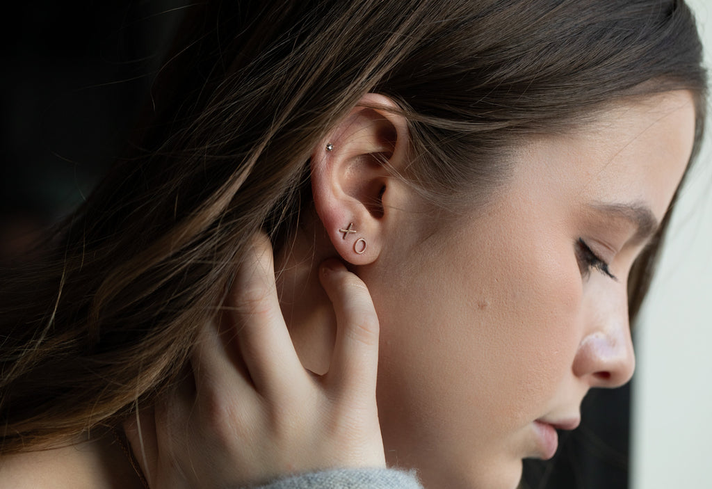 model wearing 'xo' stud earrings